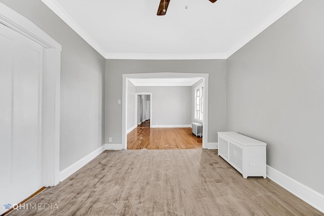 unfurnished room featuring a ceiling fan, ornamental molding, wood finished floors, and radiator