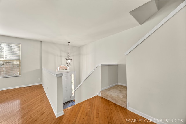 1045 Crane Pt, Elgin, IL 60124 - empty room with wood finished floors, an inviting chandelier, baseboards, and visible vents