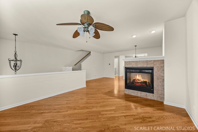 1045 Crane Pt, Elgin, IL 60124 - unfurnished living room featuring a tile fireplace, wood finished floors, ceiling fan, and baseboards