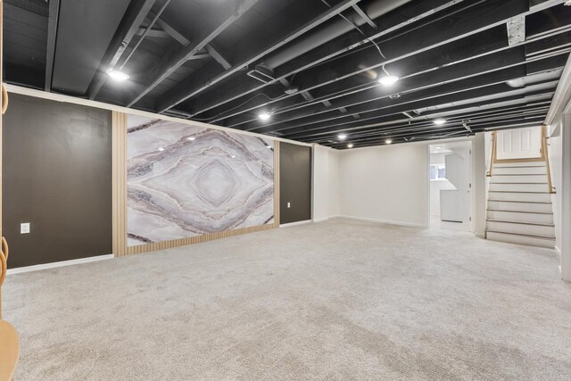 finished basement with stairway and carpet flooring