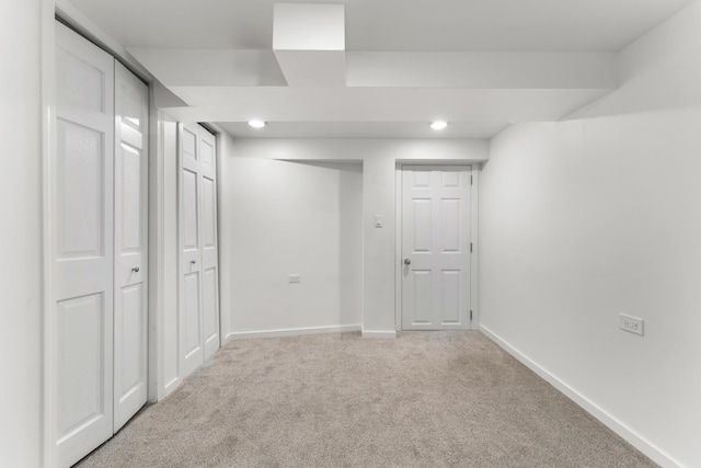 basement with light carpet, recessed lighting, and baseboards