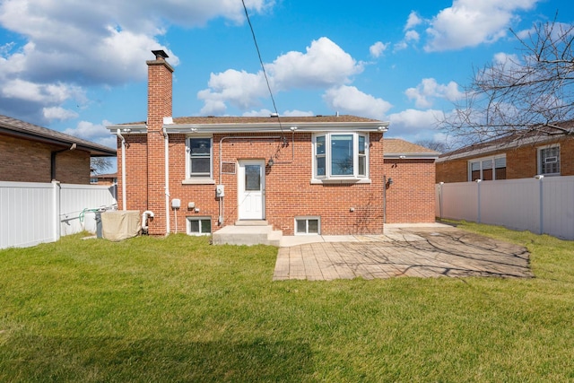 rear view of property with a yard, a fenced backyard, and brick siding