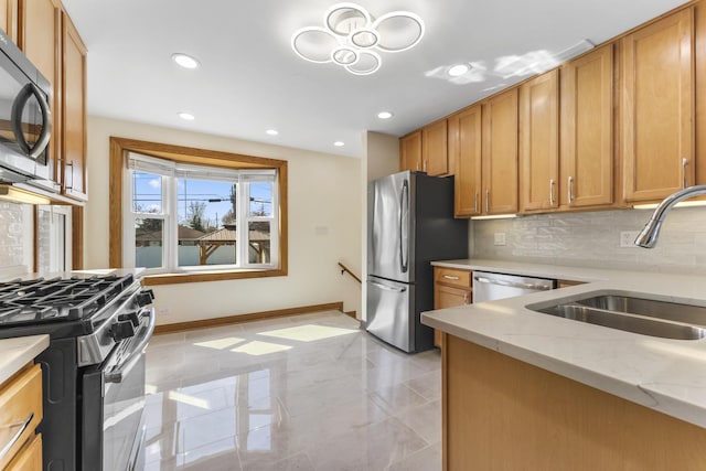 kitchen with tasteful backsplash, baseboards, a sink, appliances with stainless steel finishes, and light stone counters