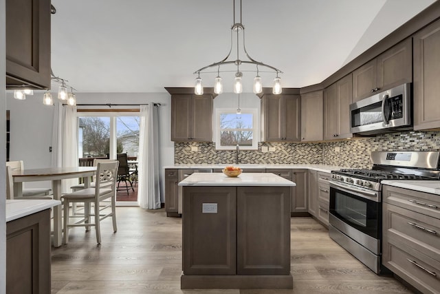 623 Coneflower Ct, Romeoville, IL 60446 - kitchen featuring dark brown cabinetry, tasteful backsplash, a kitchen island, appliances with stainless steel finishes, and light countertops