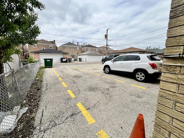 view of parking / parking lot with fence and a residential view