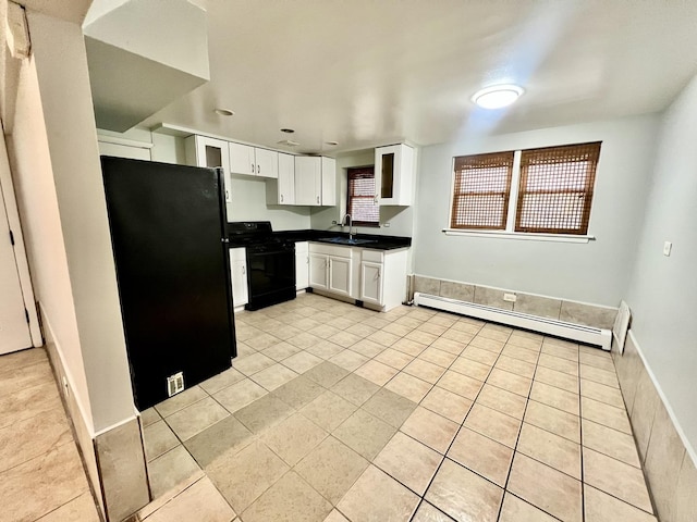 kitchen featuring black appliances, a baseboard radiator, a sink, dark countertops, and white cabinetry