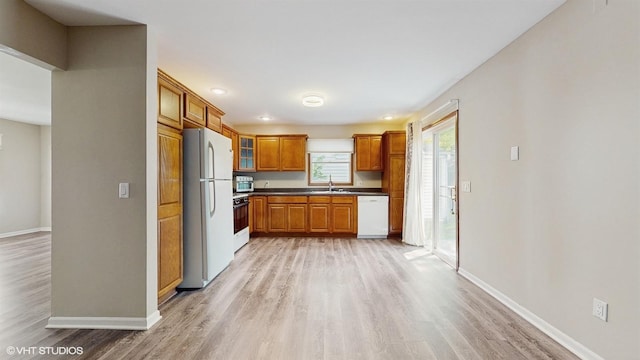 1704 Paddington Ave, Naperville, IL 60563 - kitchen with white appliances, brown cabinetry, light wood-style flooring, dark countertops, and glass insert cabinets