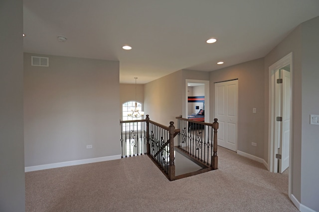 hall with visible vents, baseboards, an inviting chandelier, an upstairs landing, and carpet floors
