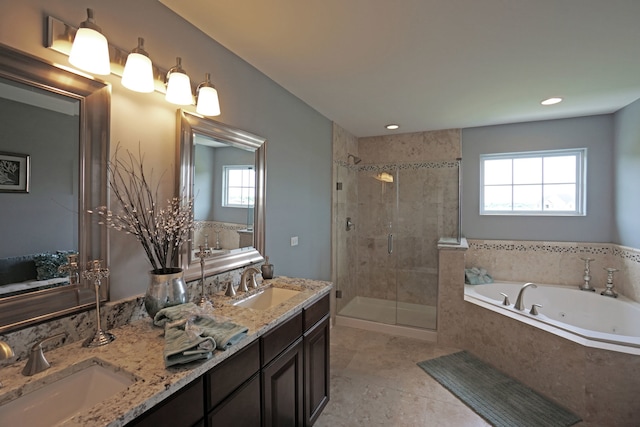 full bath with a stall shower, a jetted tub, double vanity, and a sink