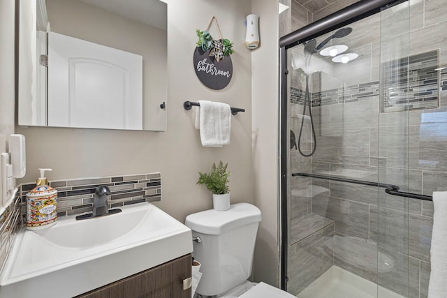 full bath with a shower stall, toilet, vanity, and decorative backsplash
