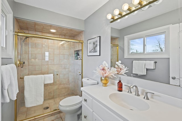 bathroom with a shower stall, toilet, and vanity