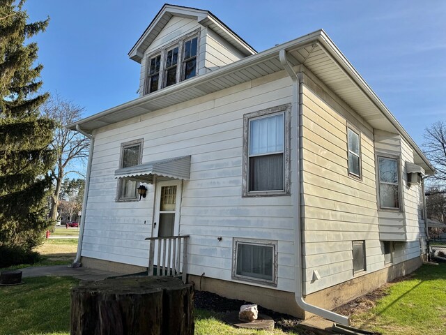 back of property featuring a yard