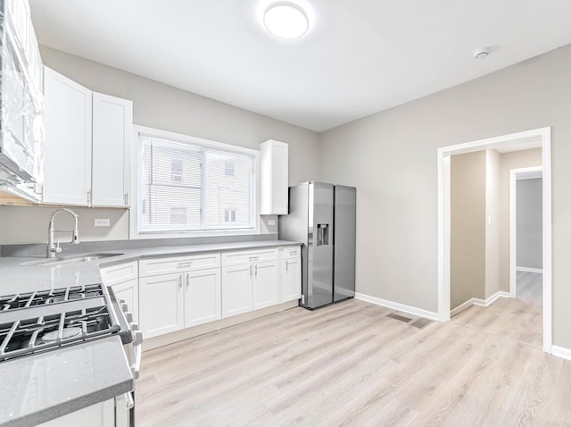 30 Washington Ave, La Grange, IL 60525 - kitchen featuring light wood-style flooring, stainless steel appliances, white cabinets, a sink, and visible vents