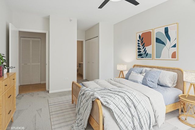bedroom with light colored carpet, a ceiling fan, baseboards, and connected bathroom
