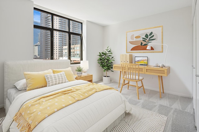 carpeted bedroom featuring a desk and baseboards