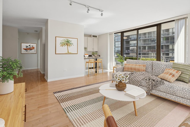 living room with baseboards, track lighting, and light wood-type flooring