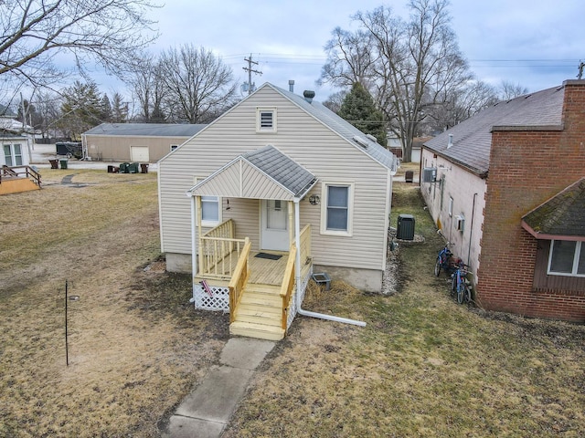 back of house with central AC and a lawn