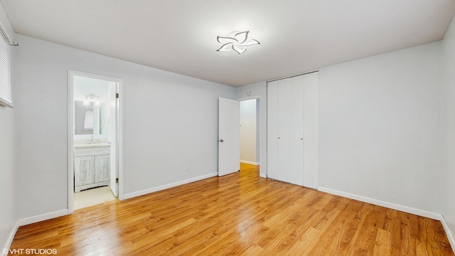 1317 Mackinaw Ave, Calumet City, IL 60409 - unfurnished bedroom featuring light wood-style floors, baseboards, ensuite bathroom, and a closet