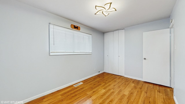 1317 Mackinaw Ave, Calumet City, IL 60409 - unfurnished bedroom featuring baseboards, visible vents, light wood finished floors, and a closet