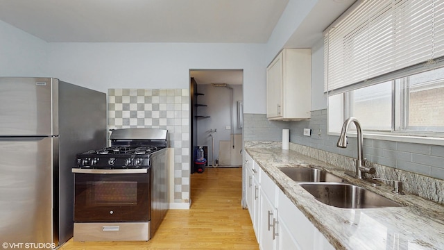 1317 Mackinaw Ave, Calumet City, IL 60409 - kitchen featuring decorative backsplash, freestanding refrigerator, range with gas cooktop, light stone counters, and a sink