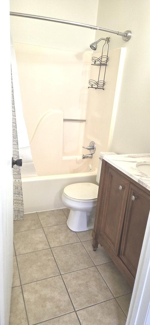 bathroom featuring bathtub / shower combination, toilet, tile patterned flooring, and vanity