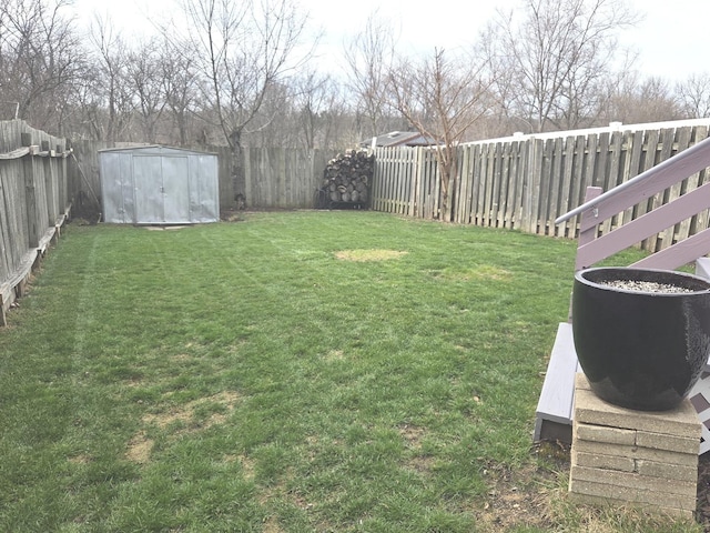 view of yard featuring an outbuilding, a fenced backyard, and a shed