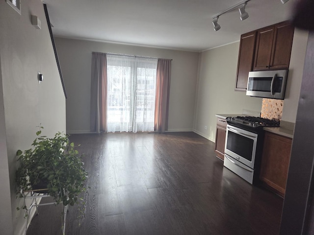 kitchen featuring light countertops, stainless steel appliances, baseboards, dark wood finished floors, and track lighting