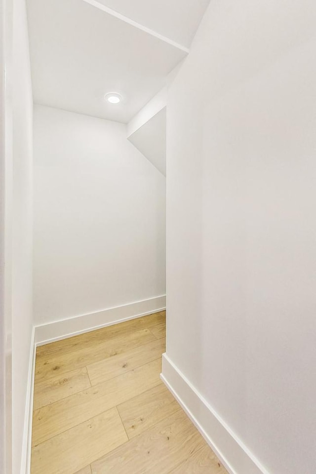 interior space featuring light wood-type flooring and vaulted ceiling