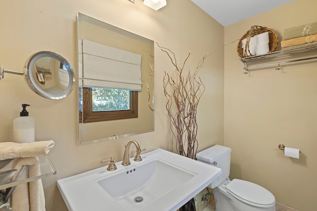 half bathroom featuring a sink and toilet