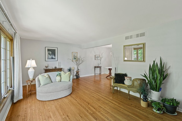 living area with light wood-style flooring and baseboards