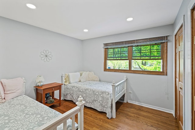bedroom featuring wood finished floors, baseboards, and recessed lighting