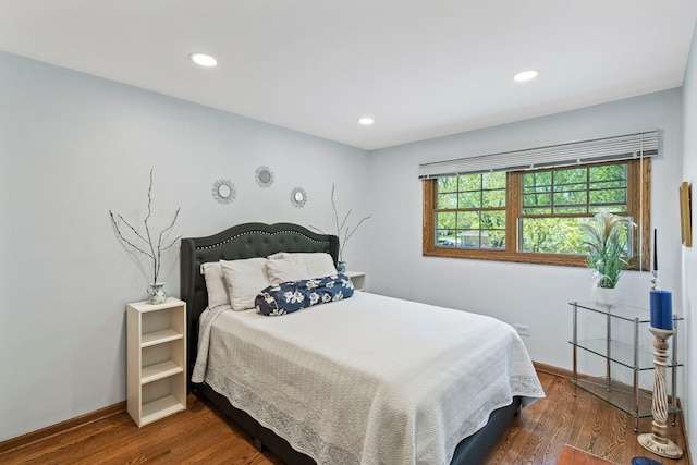 bedroom with wood finished floors, baseboards, and recessed lighting