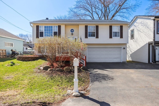 view of front of property with an attached garage, aphalt driveway, and a front yard