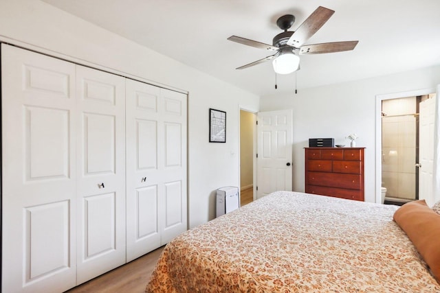 bedroom with light wood-style floors, a ceiling fan, a closet, and ensuite bath