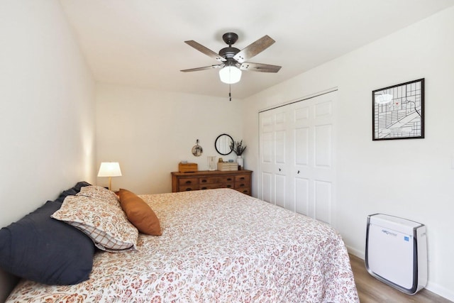 bedroom with a closet, baseboards, ceiling fan, and light wood-style floors