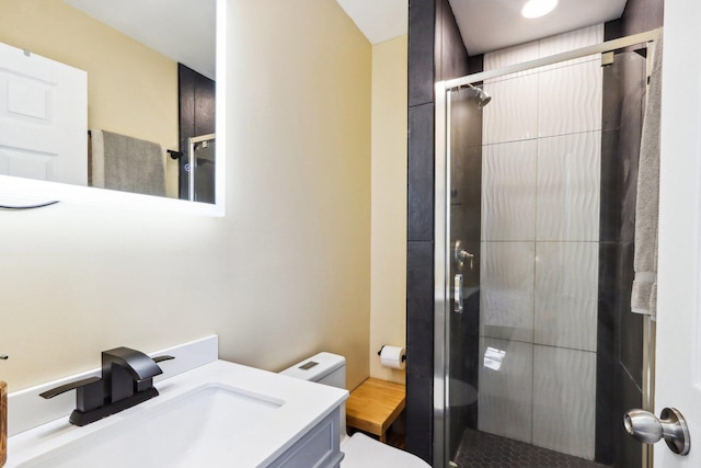 bathroom with vanity, a shower stall, and toilet