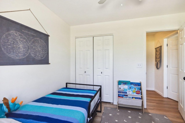 bedroom featuring a closet, baseboards, ceiling fan, and wood finished floors