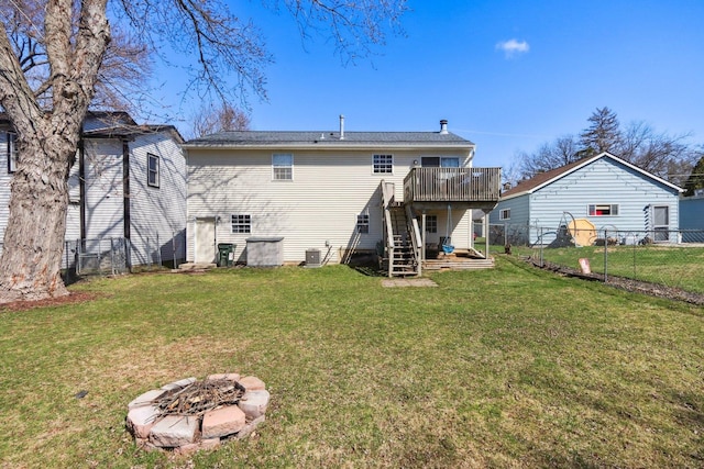 rear view of property with a fire pit, a wooden deck, stairs, and a fenced backyard