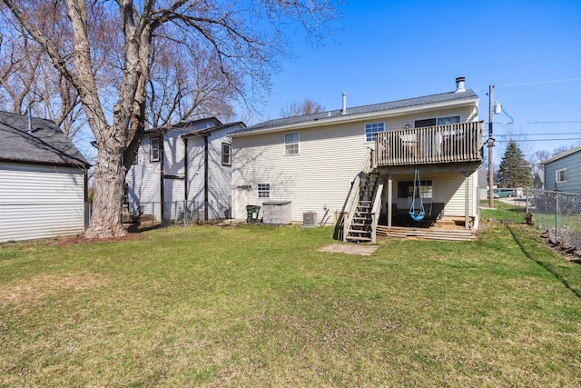 rear view of property with fence, a deck, stairway, central AC unit, and a lawn