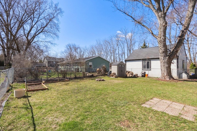 view of yard with a fenced backyard, an outdoor structure, a garden, and a shed