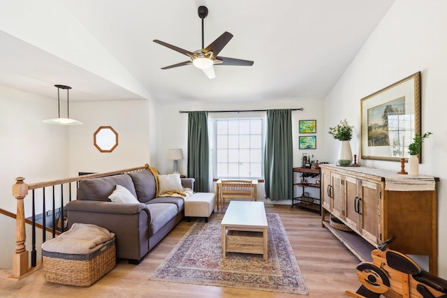 living room featuring light wood-style flooring, ceiling fan, and vaulted ceiling
