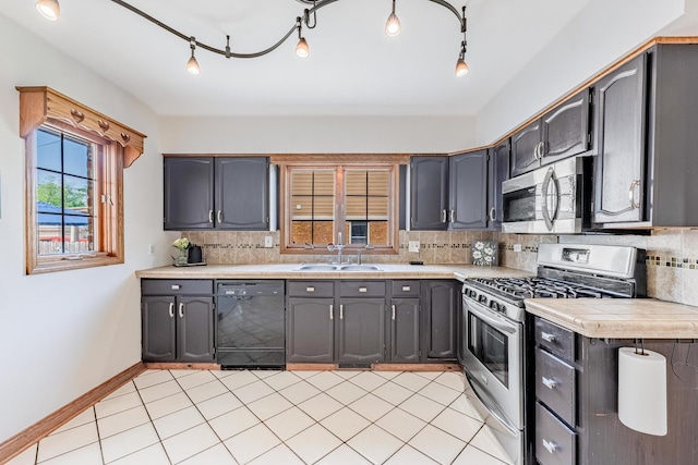 7733 Suburban Ln, Bridgeview, IL 60455 - kitchen featuring appliances with stainless steel finishes, tasteful backsplash, track lighting, and light tile patterned floors