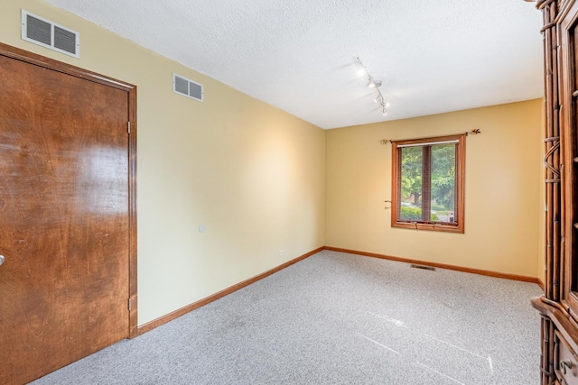 7733 Suburban Ln, Bridgeview, IL 60455 - carpeted spare room featuring rail lighting and a textured ceiling