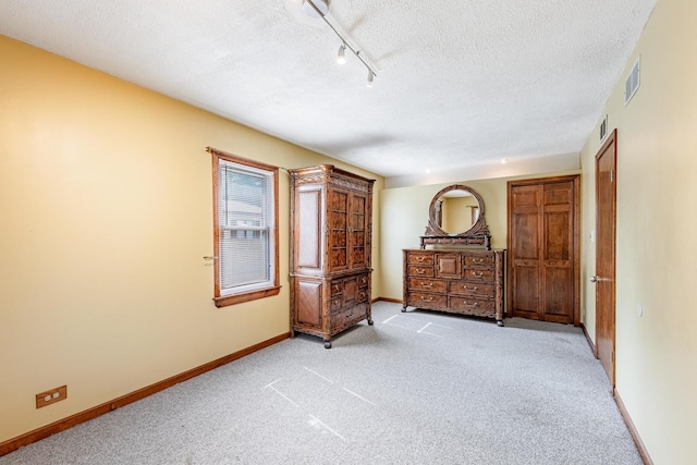7733 Suburban Ln, Bridgeview, IL 60455 - bedroom with light carpet, a textured ceiling, and track lighting