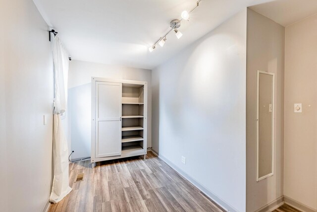 7733 Suburban Ln, Bridgeview, IL 60455 - corridor featuring wood finished floors, lofted ceiling, and rail lighting