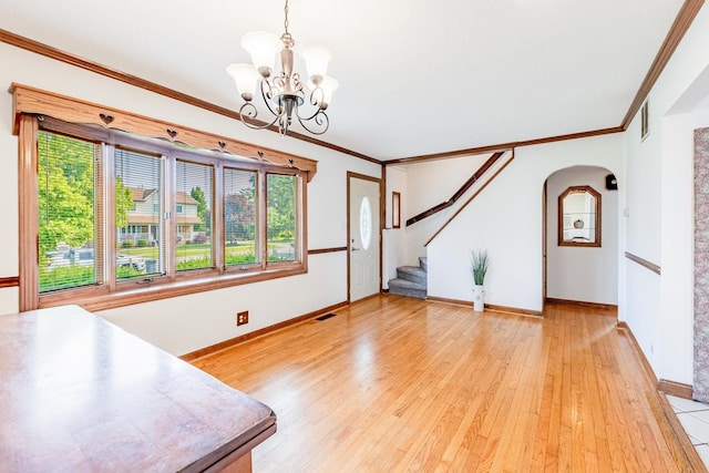7733 Suburban Ln, Bridgeview, IL 60455 - unfurnished living room with healthy amount of natural light, a chandelier, arched walkways, stairs, and crown molding
