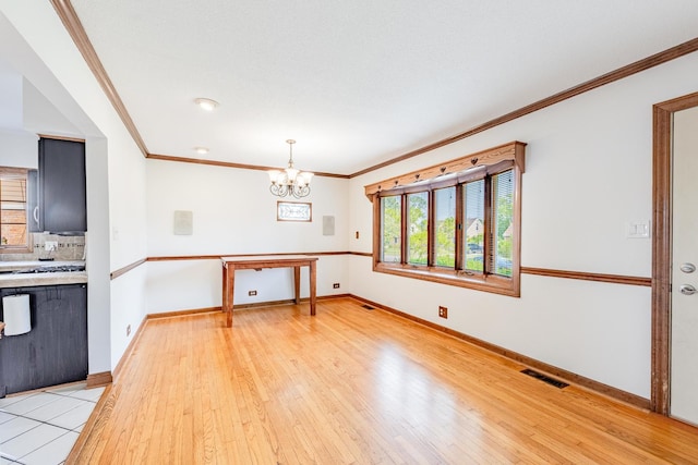 7733 Suburban Ln, Bridgeview, IL 60455 - kitchen with a chandelier, light countertops, light wood-style flooring, ornamental molding, and tasteful backsplash