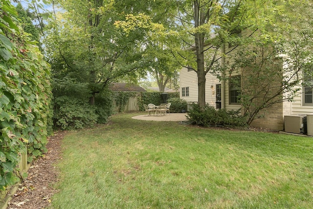 view of yard with a patio, fence, and central air condition unit