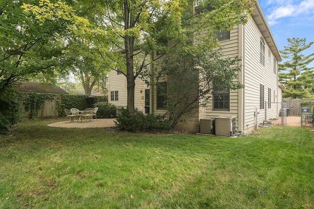 rear view of property featuring central AC, a fenced backyard, a yard, and a patio area