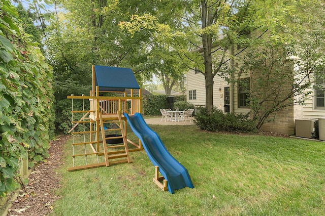 view of jungle gym featuring central AC, a yard, and a patio area